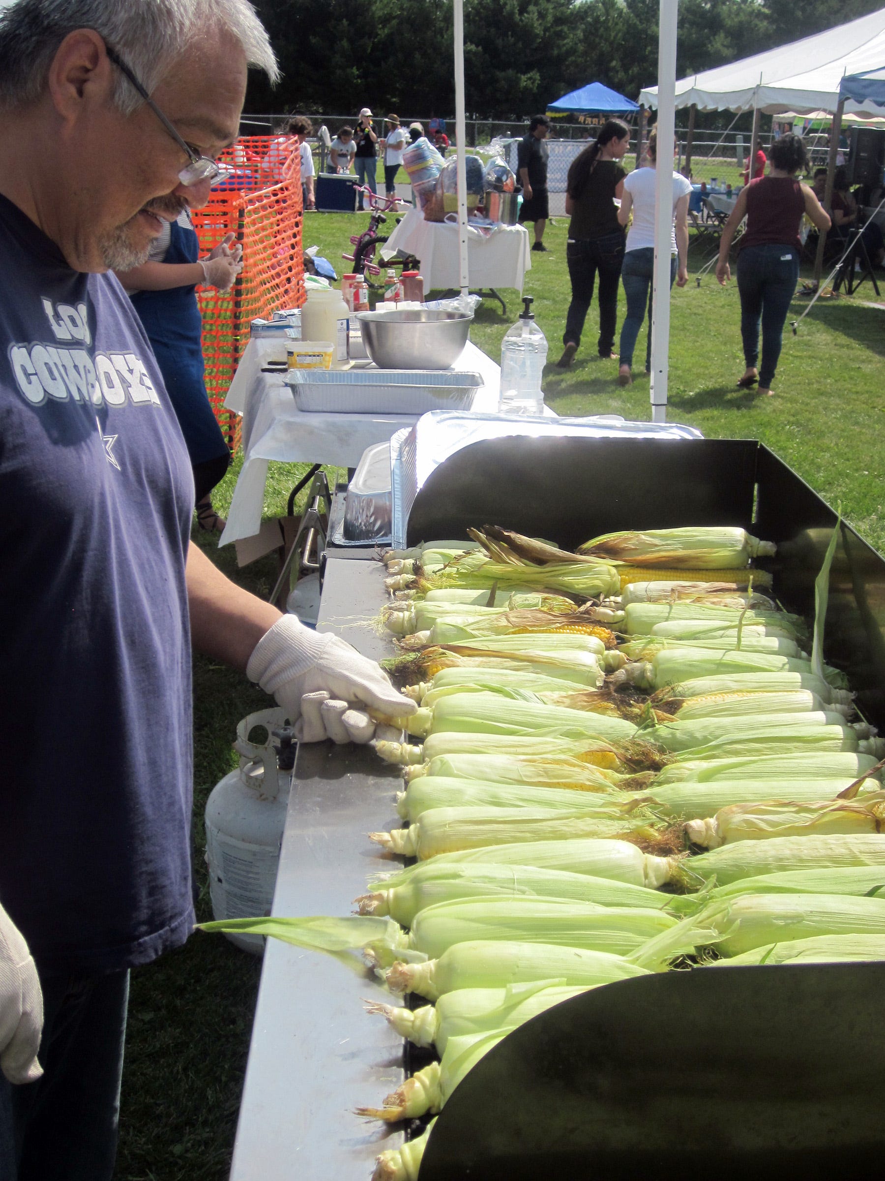 Juan Lopez, UMOS staff, prepares roasted corn for the annual UMOS annual farmworker appreciation day picnic on Aug. 6 in Berlin.