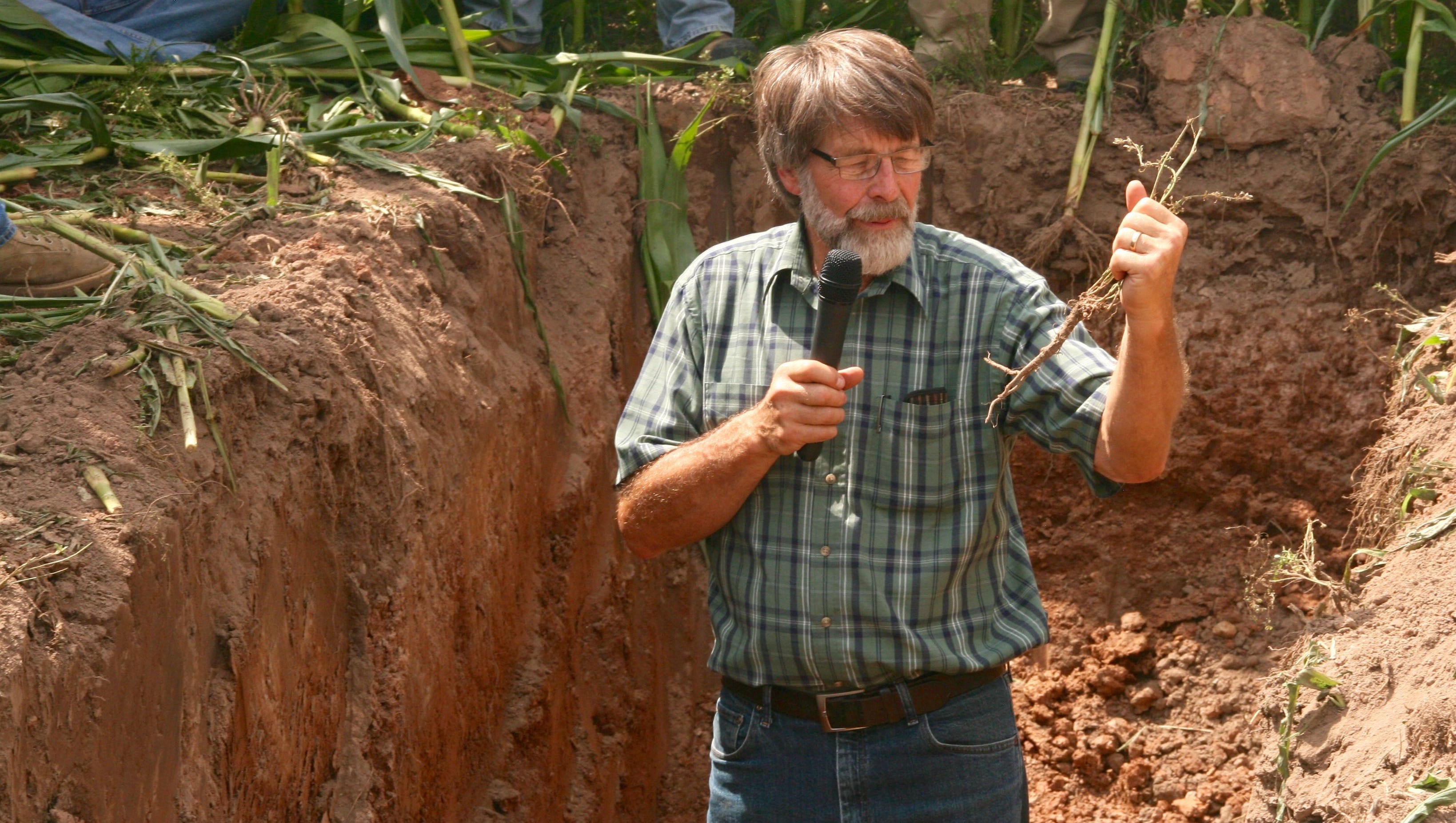 Crop consultant Jim Martindale examines an alfalfa root which is almost completely devoid of important lateral roots.