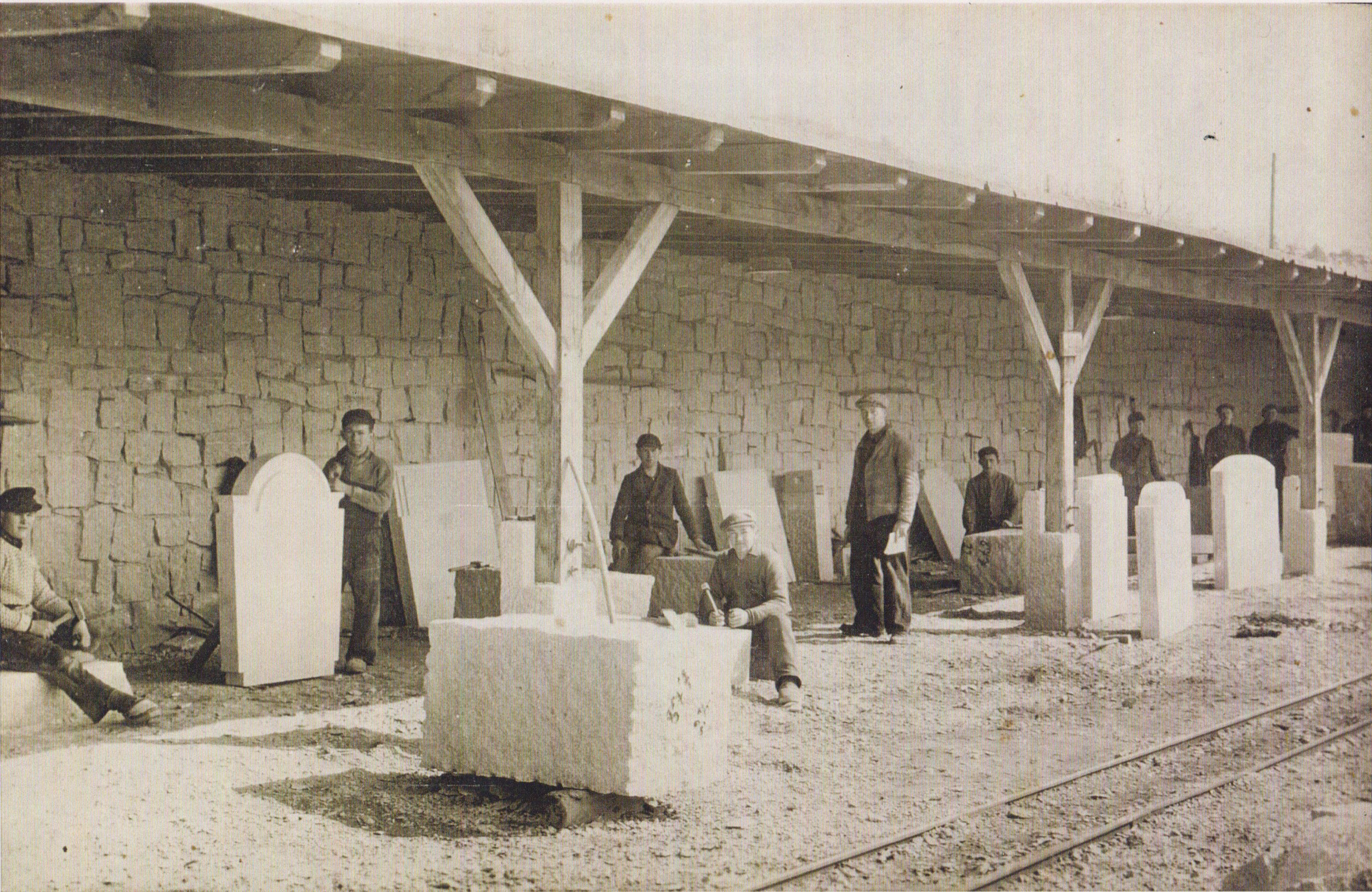 Kurt Pechmann, center, sits in front of a large block of granite in Germany in April 1941. At the time, he was already drafted into the German army, the government said he needed to finish this work first. The stone will become a window sill in Berlin's Bundestag building, said his son, Gerhard Pechmann.