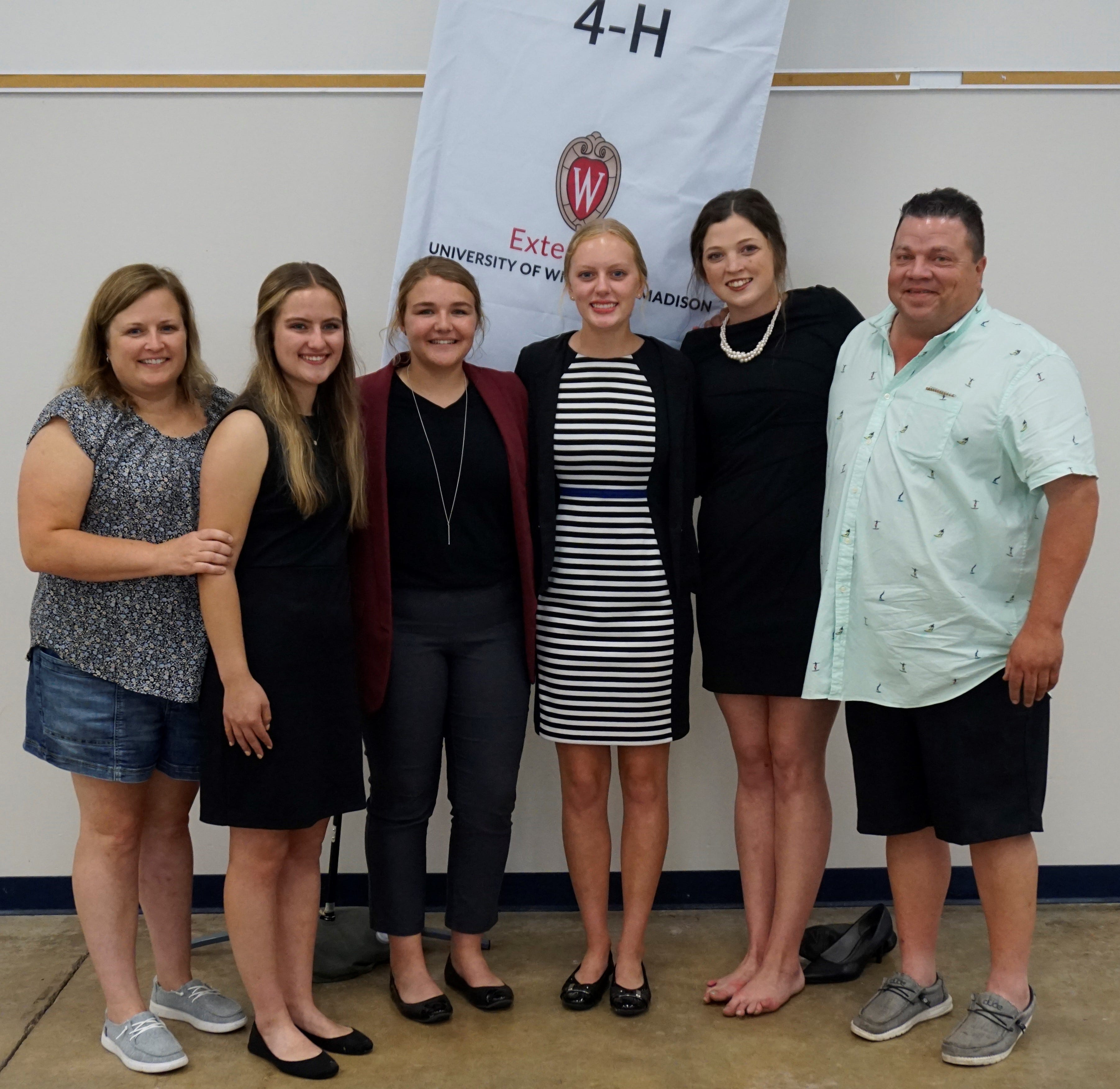 The Manitowoc County Senior Dairy Judging Team advanced to the National 4-H Dairy Cattle Judging contest next month at World Dairy Expo by finishing first place at the State 4-H Senior Dairy Judging Contest on August 9, 2021. Coached by Angie Ulness, far left, and Paul Siemers, far right, are Clarissa Ulness, second from left, Emma Vos, Jenna Gries, and Lauren Siemers.