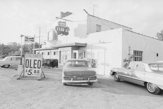 A car with Wisconsin license plates bearing the state's "America's Dairyland" slogan is parked just across the state line in Illinois at one of many impromptu dealers offering colored oleomargarine-illegal in Wisconsin for more than two decades--at bargain prices in case lots, September 15,1966.